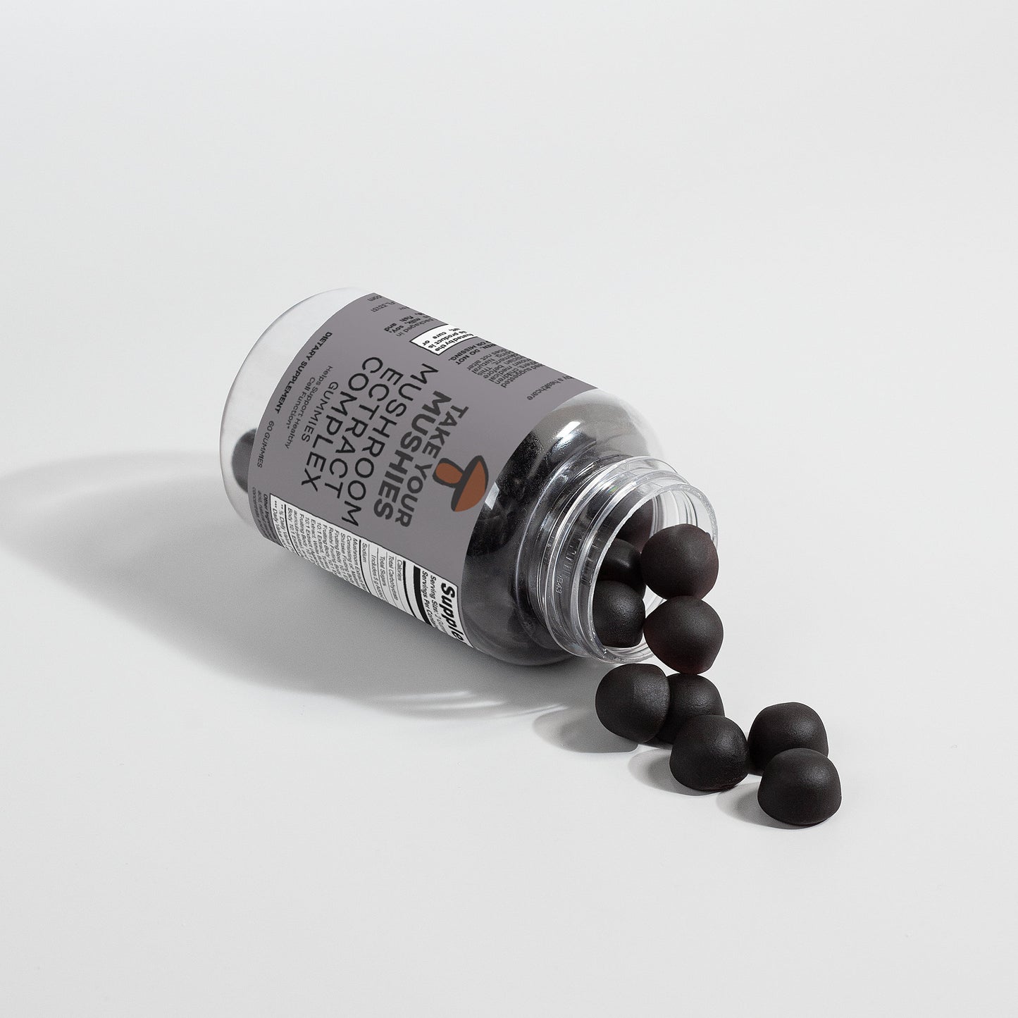 Bottle of supplements with black capsules spilling out on a light gray background